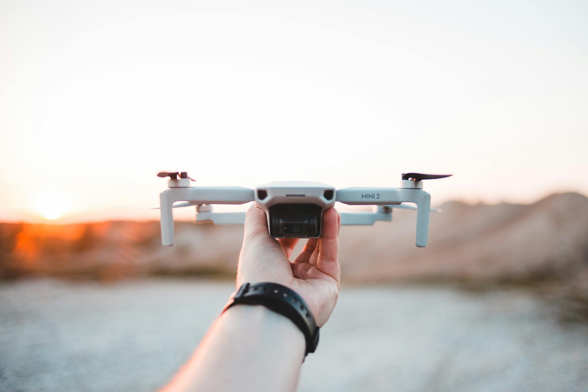 A person holding a drone in an outdoor setting, showcasing modern technology.