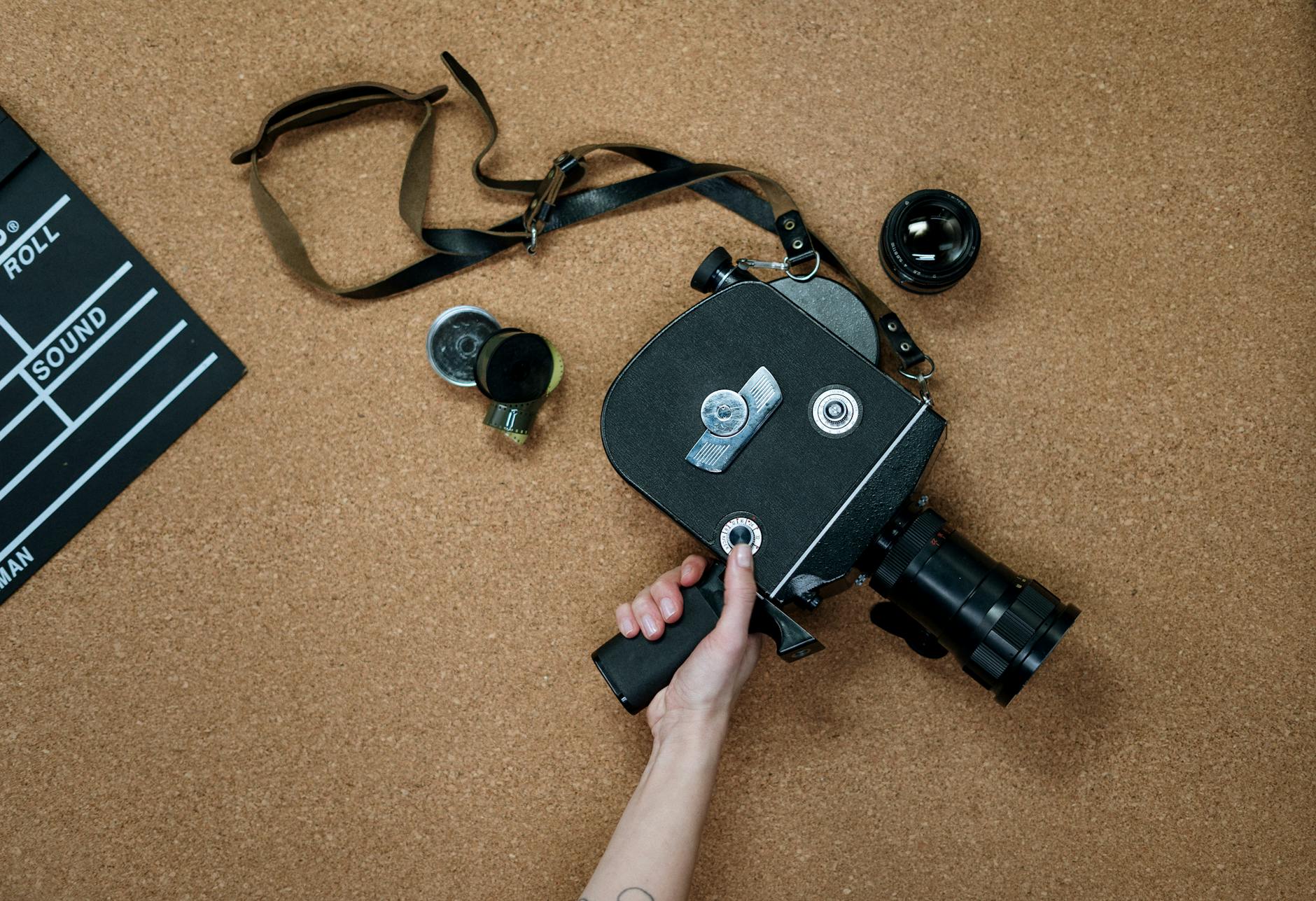 Flat lay of a vintage film camera alongside a clapboard on a cork surface, ideal for cinematic themes.