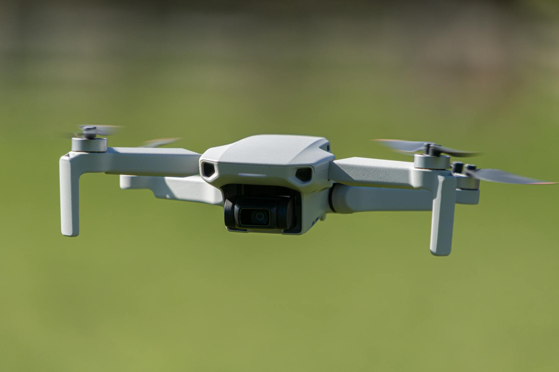 Aerial drone captured mid-flight over a lush green field in Leeds, UK.