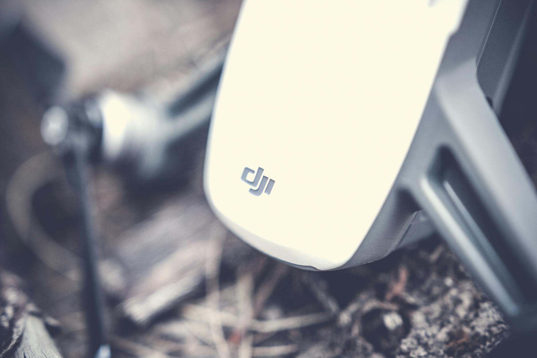 Detailed shot of a drone's body resting on outdoor ground, showcasing technology.
