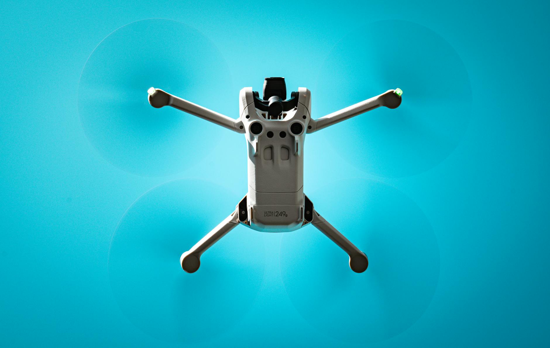 Aerial view of a drone flying against a vibrant blue sky, showcasing modern technology.