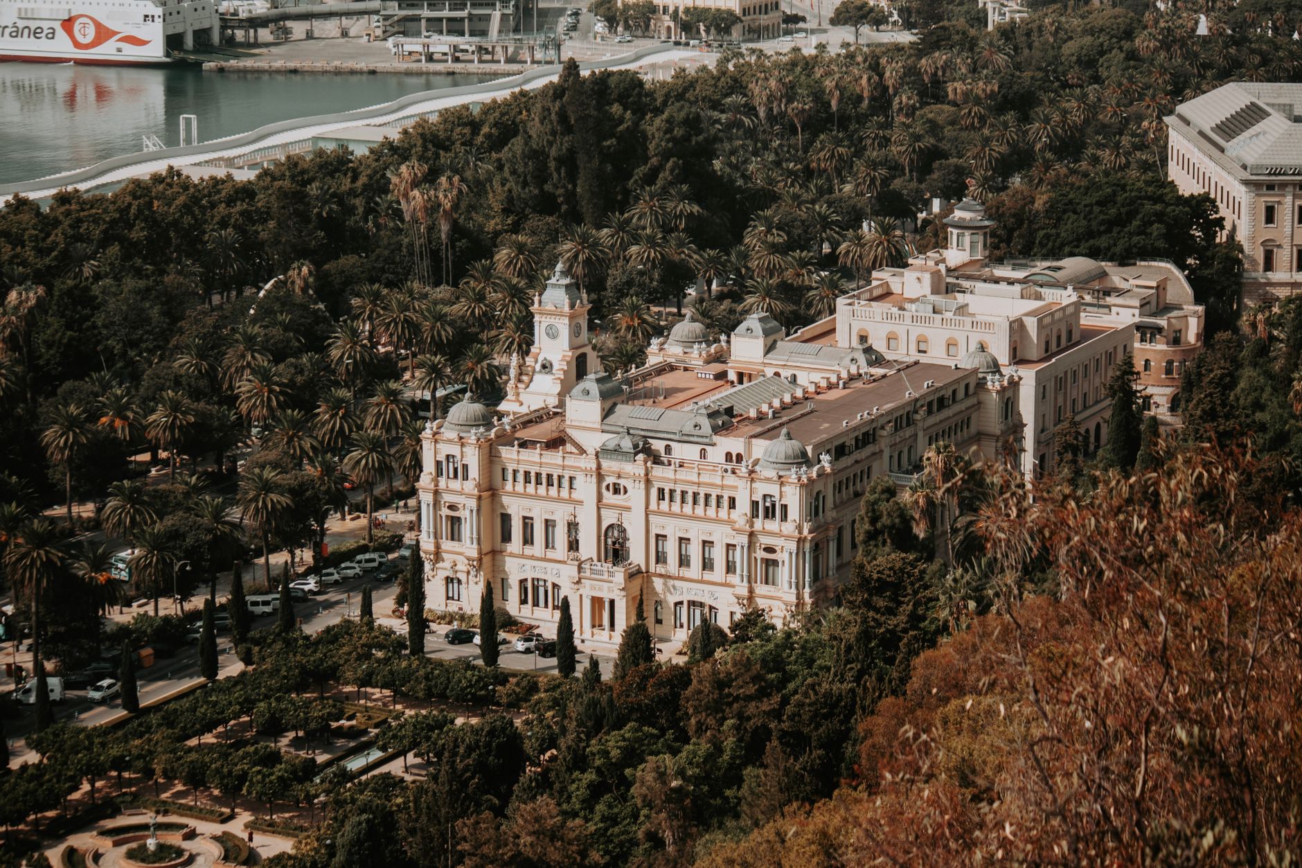 Captivating aerial view of the historic city council building amidst lush greenery in Malaga, Spain.